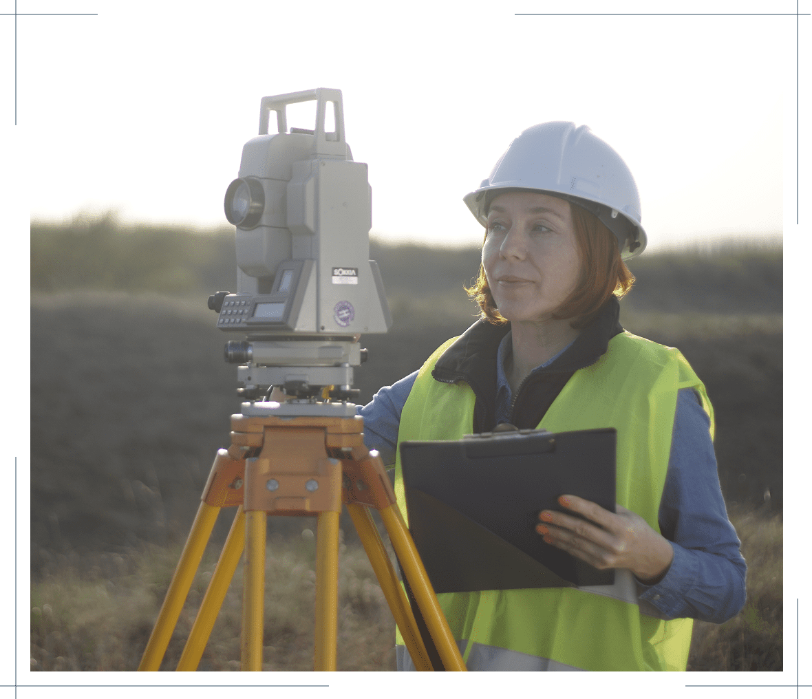 Surveyor using equipment in fieldwork setting.